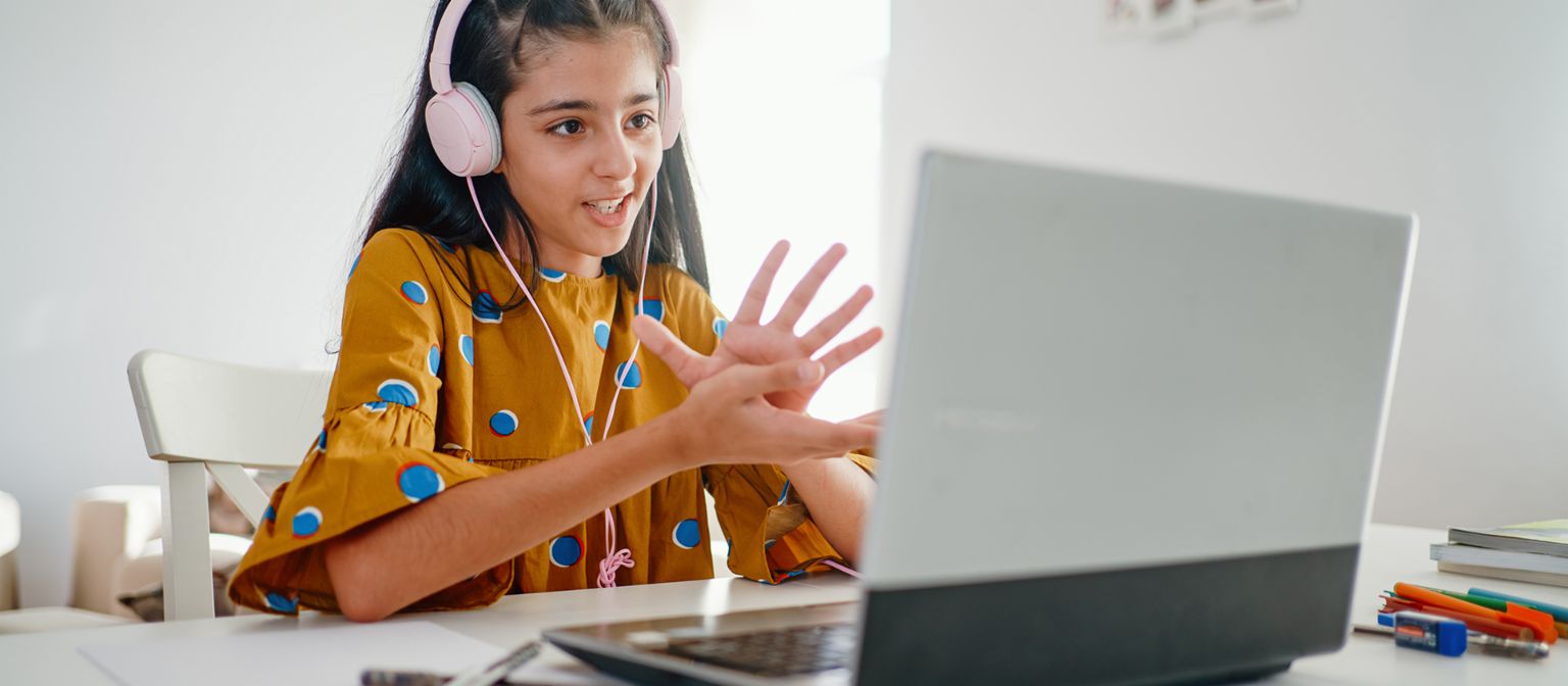 Finanzbildung ist Verantwortung: Mädchen sitzt am Laptop und nimmt an Online-Unterricht teil. 