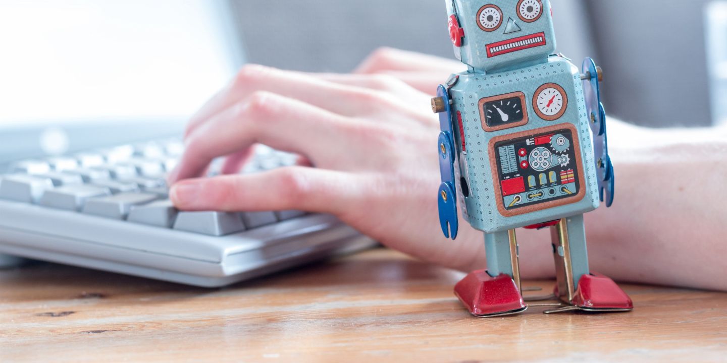 Robotic process automation: A robot figure in front of a computer.