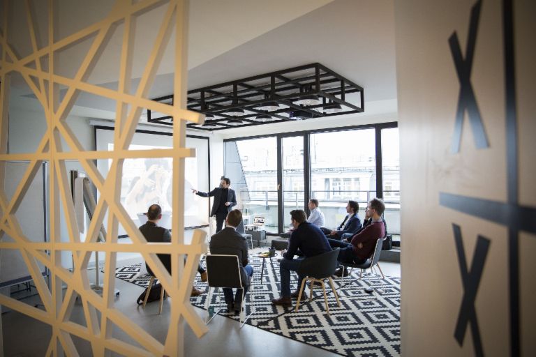 Why EOS is not a startup – but is still agile: A group of people at a meeting. Why EOS is not a startup – but is still agile: A group of people at a meeting.
