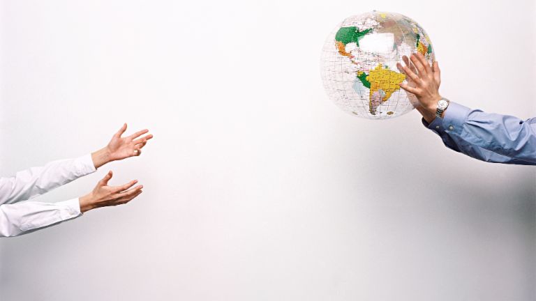 Two men throw a plastic globe to one another