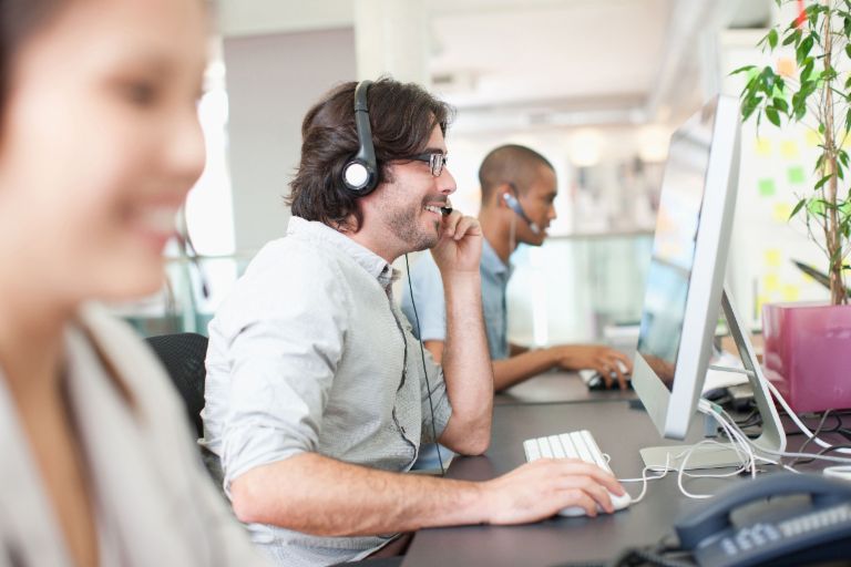 Photo of call center staff wearing headsets and making phone calls at their computers Felix Beutler, Senior Manager International Business Development at the EOS Cross-border Center.