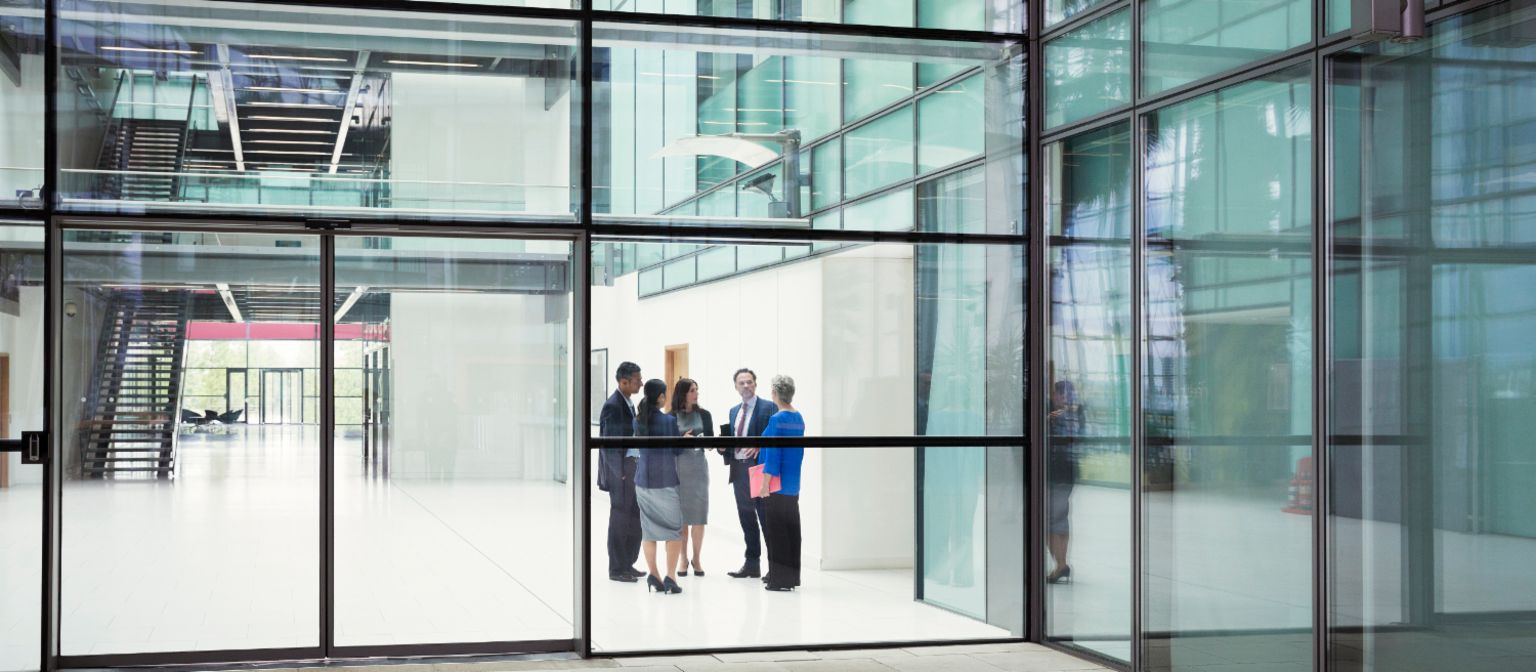The sale of non-performing real estate portfolios: People standing in the entrance of an office building.