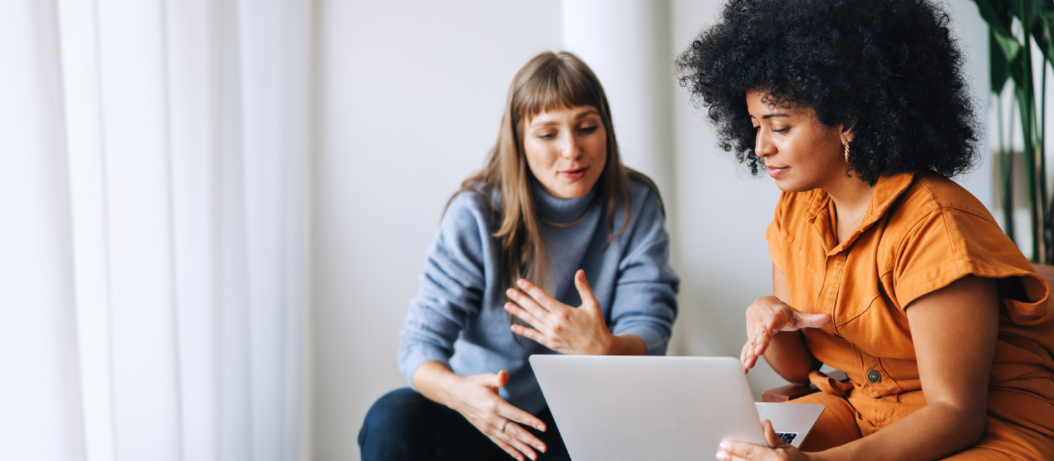 Jonge vrouw met haar mobiele telefoon naast een EOS-teamlid met koptelefoon en twee vrouwen die met elkaar praten.
