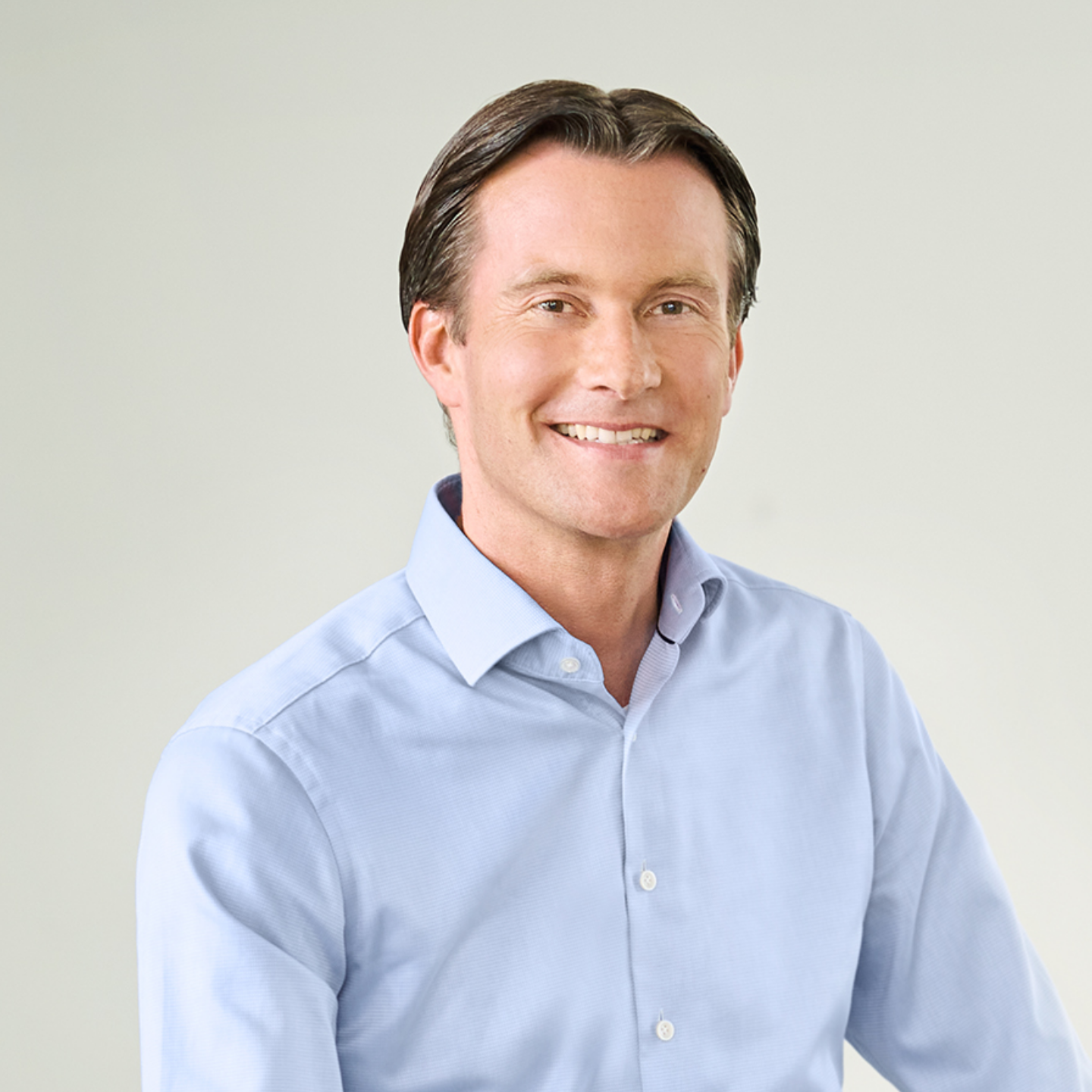 Carsten Tidow, man in a light-blue shirt sitting casually in a bright room.